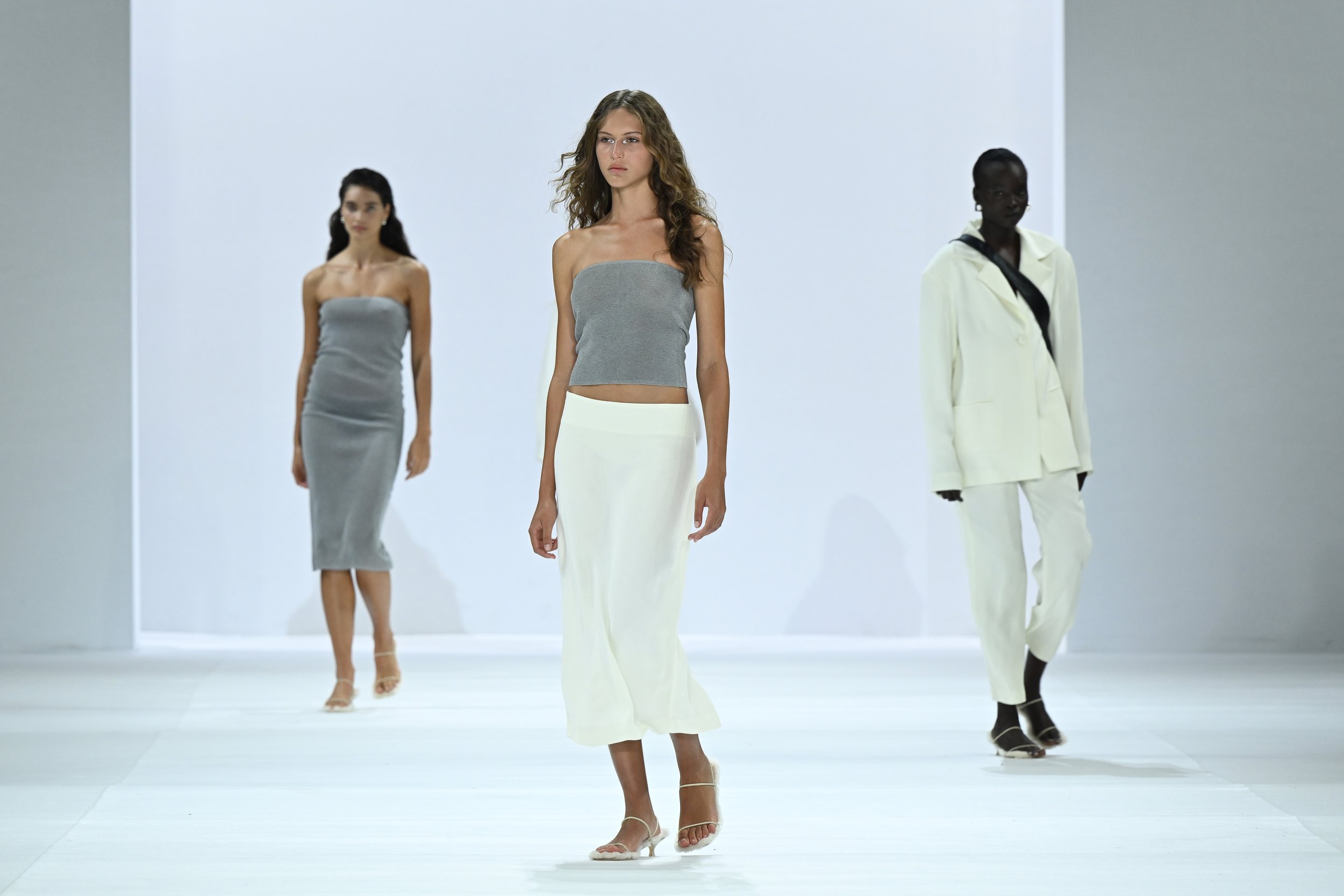 Fashion week runway show featuring three models